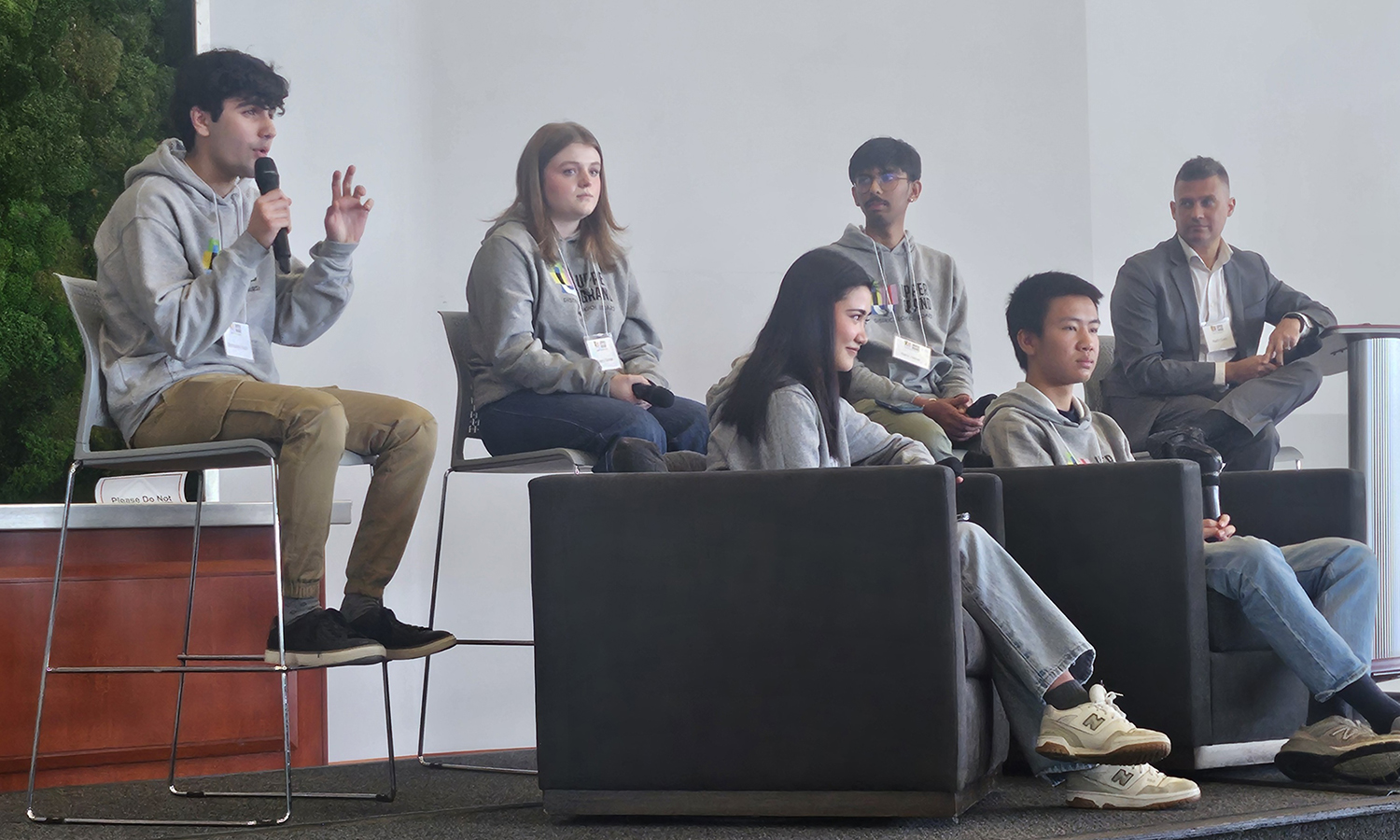 Students sit on a stage