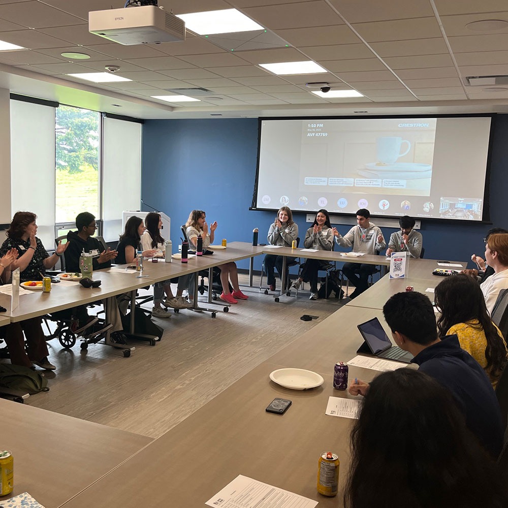 UGDSB students sit in a conference meeting discussing AI.