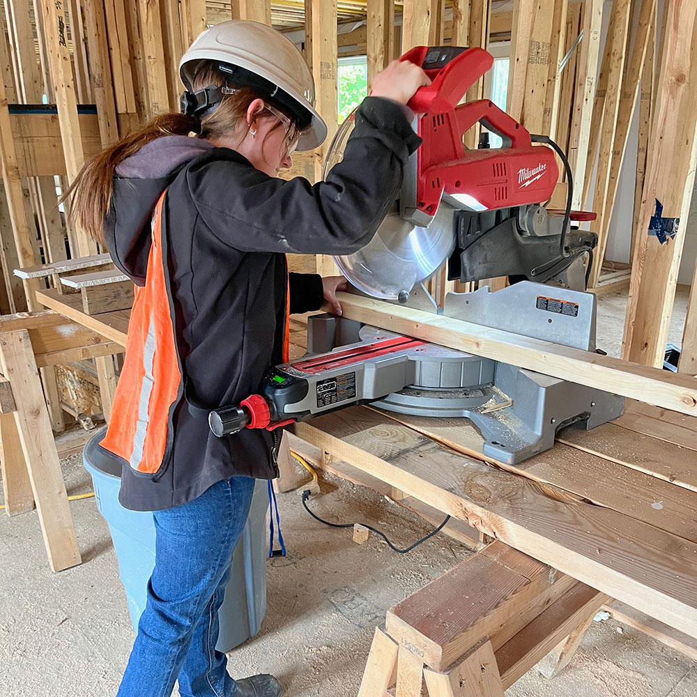A female student uses a table saw.