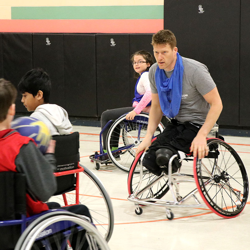 Pat Anderson playing wheelchair basketball with students