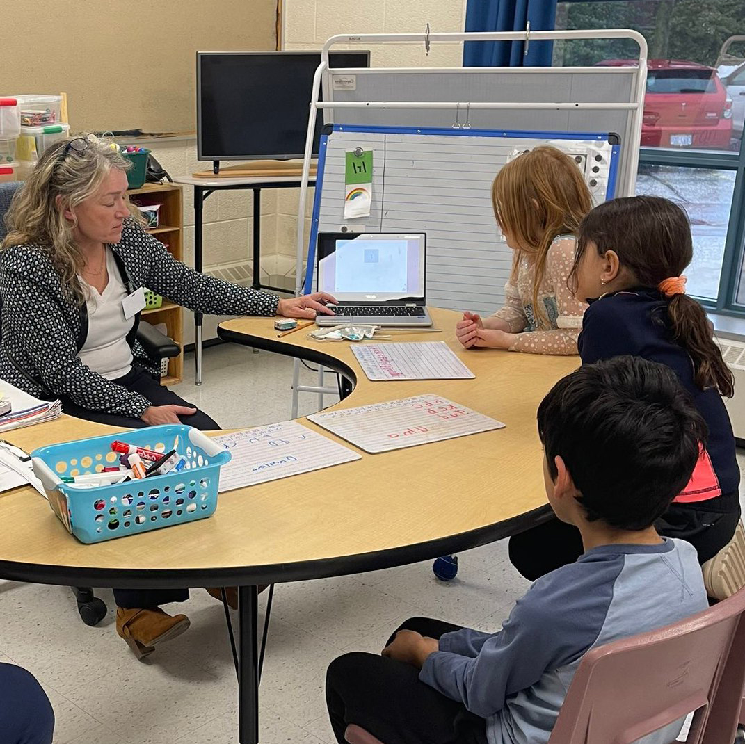 An early reading teacher instructing a small group of students.