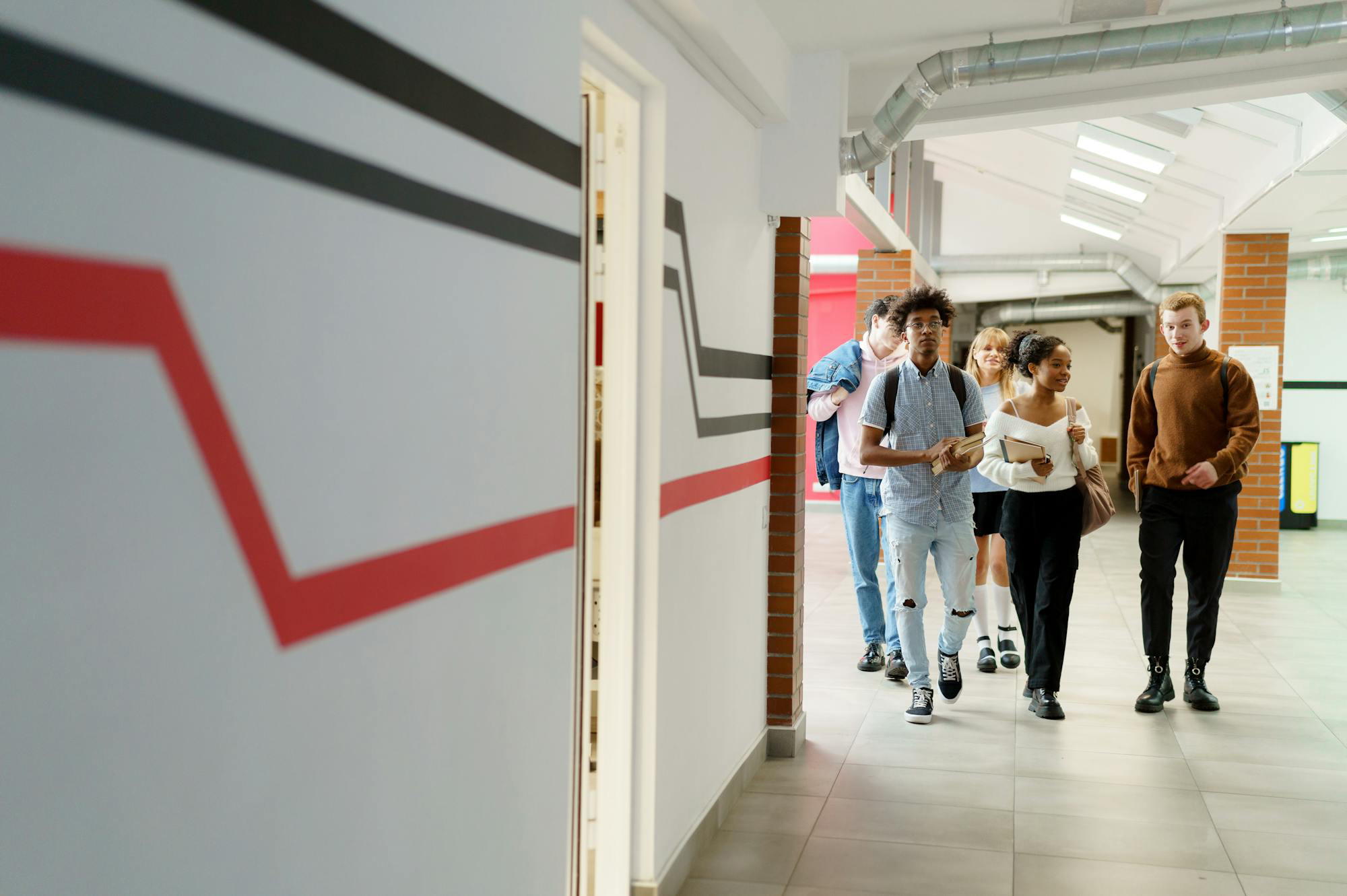 students walking down a hallway with painted orange and blue lines