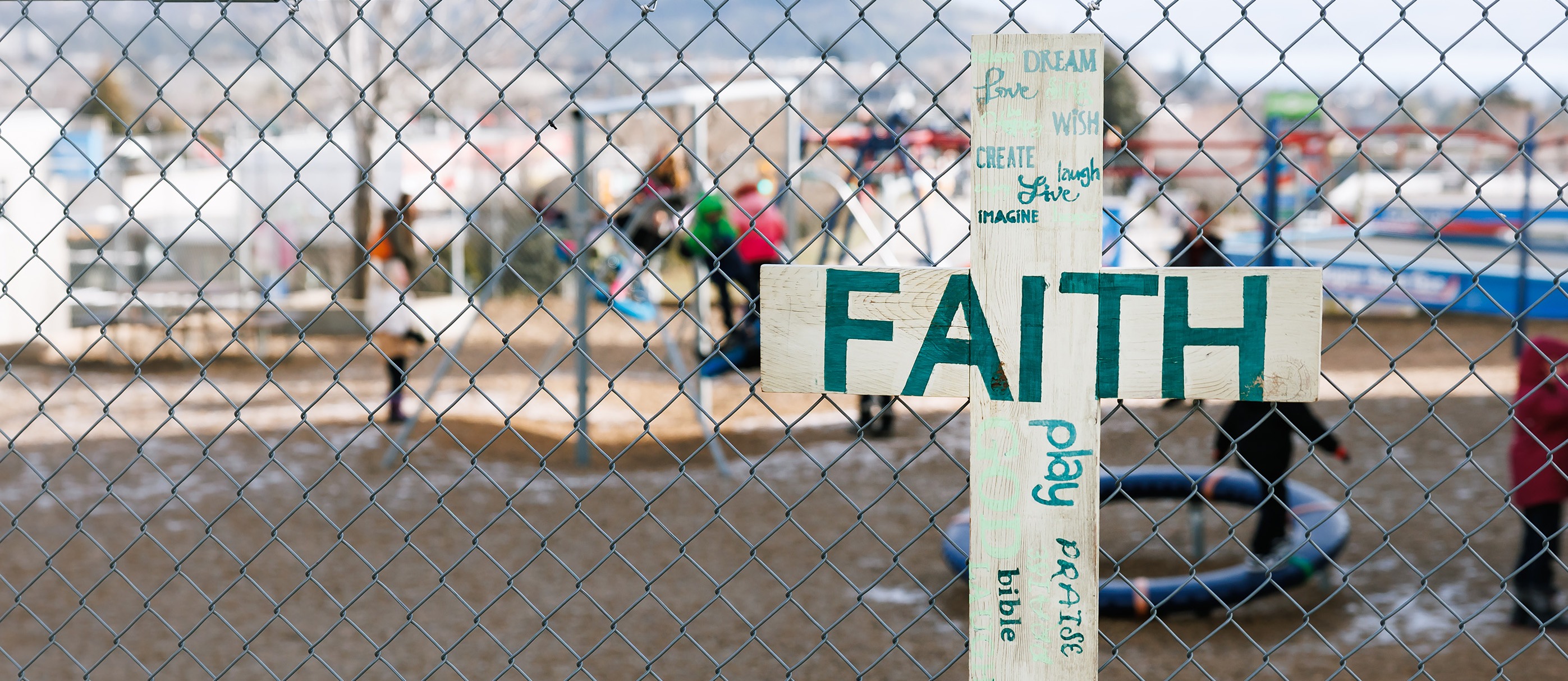 cross sign in front of fence