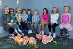 group of children sitting by wall outside