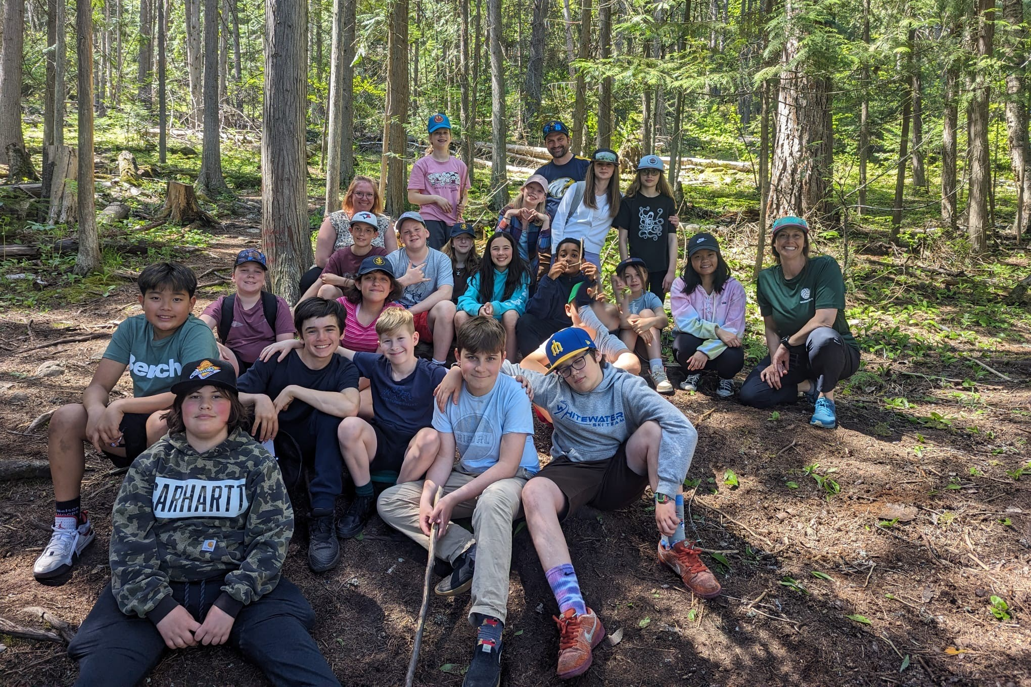 group of students sitting outside with teachers