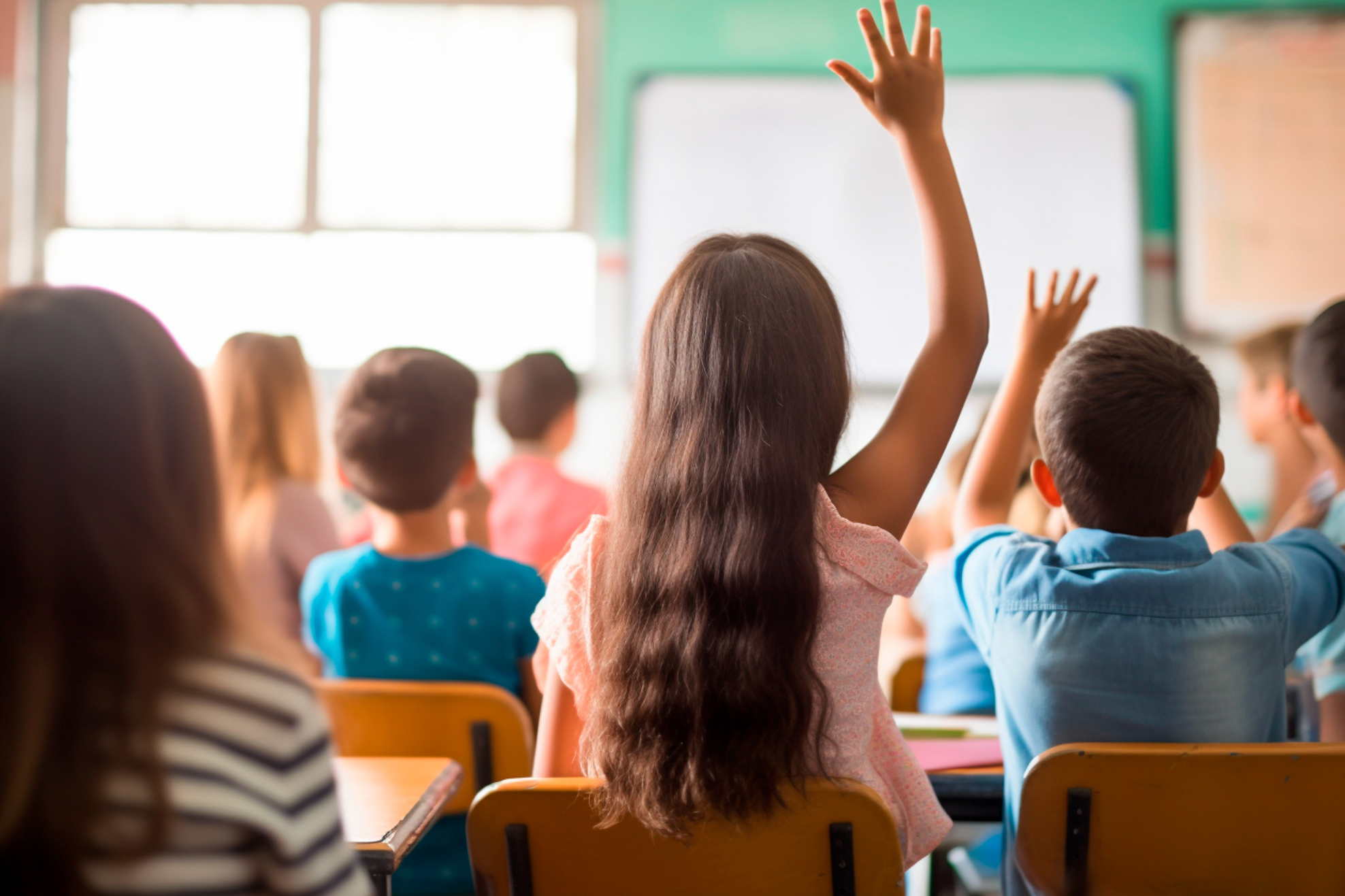 Students in classroom raising their hands