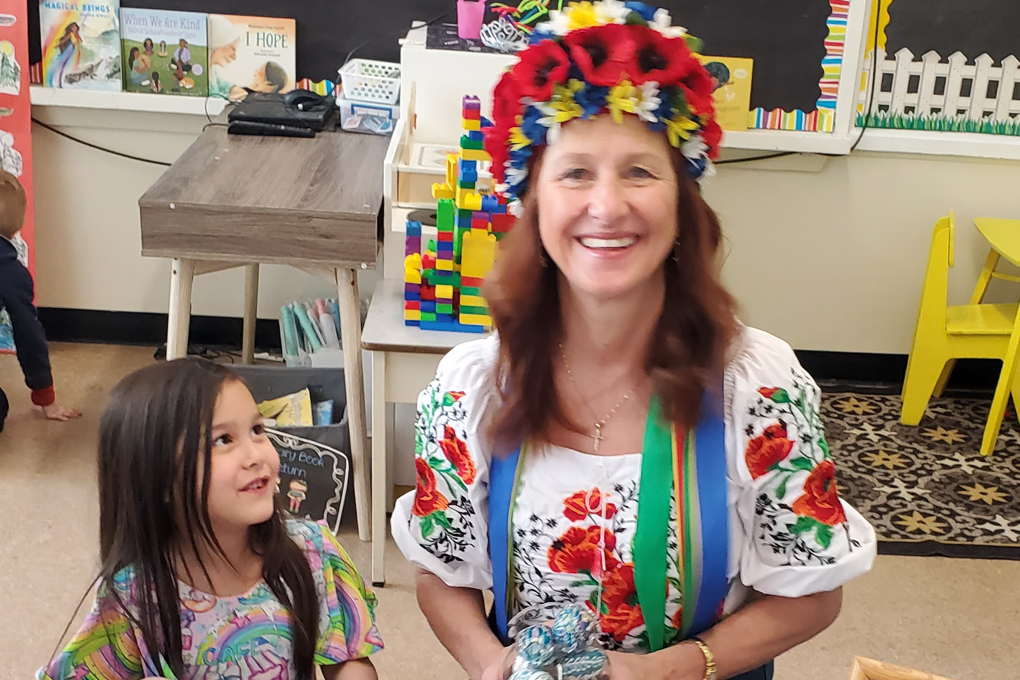 Student looking up at teacher with a flower crown on her head