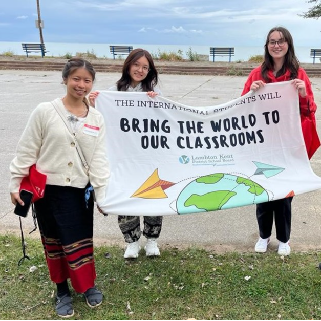 International students holding welcome to LKDSB flag at welcome event