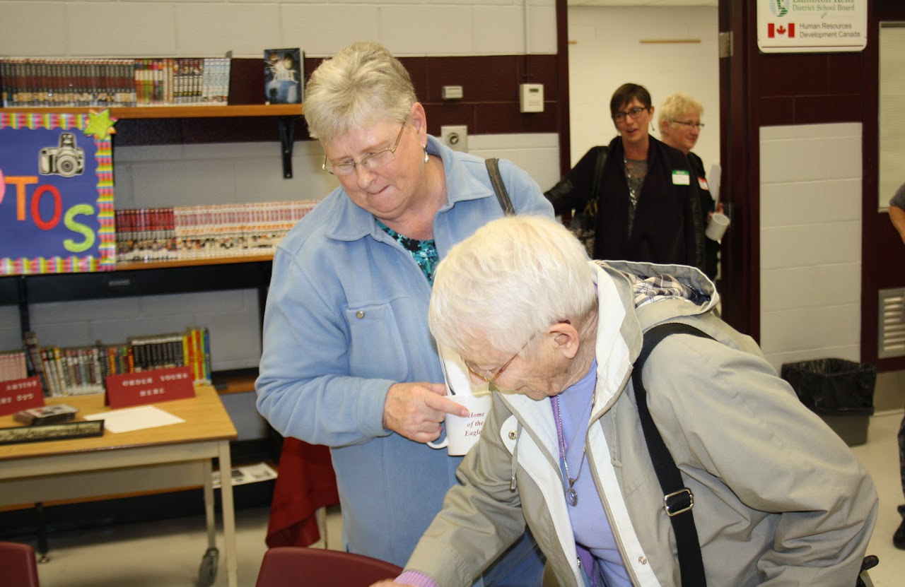 two elderly people signing papers