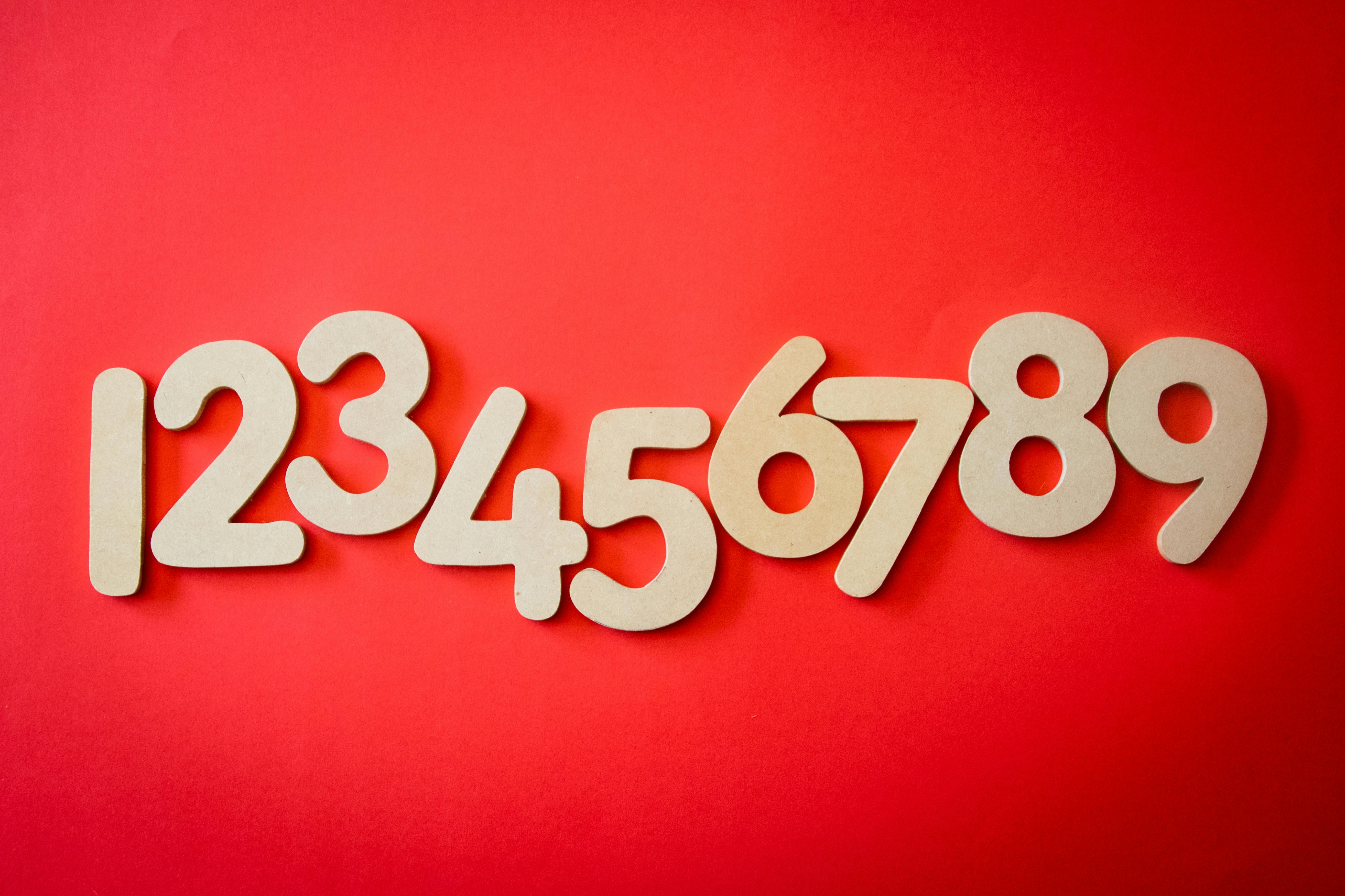 Wooden numbers 1 through 9 on a red background