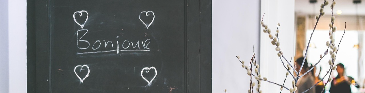 Photo of a black and white wall with "Bonjour" written on it in chalk