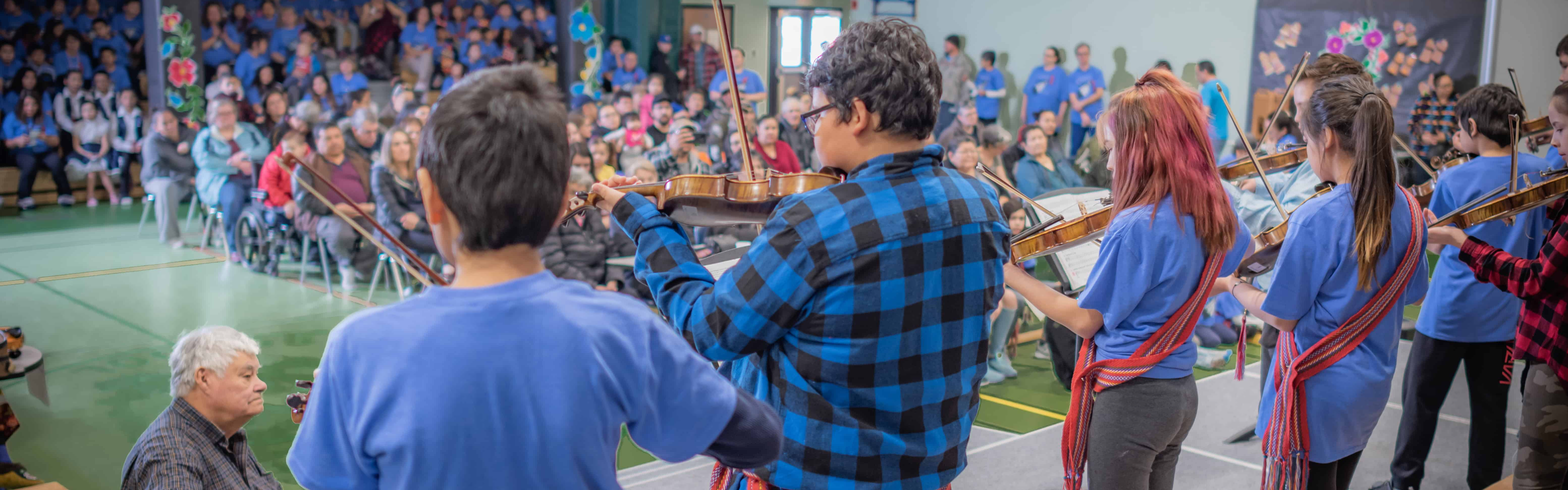Students playing instruments on stage.